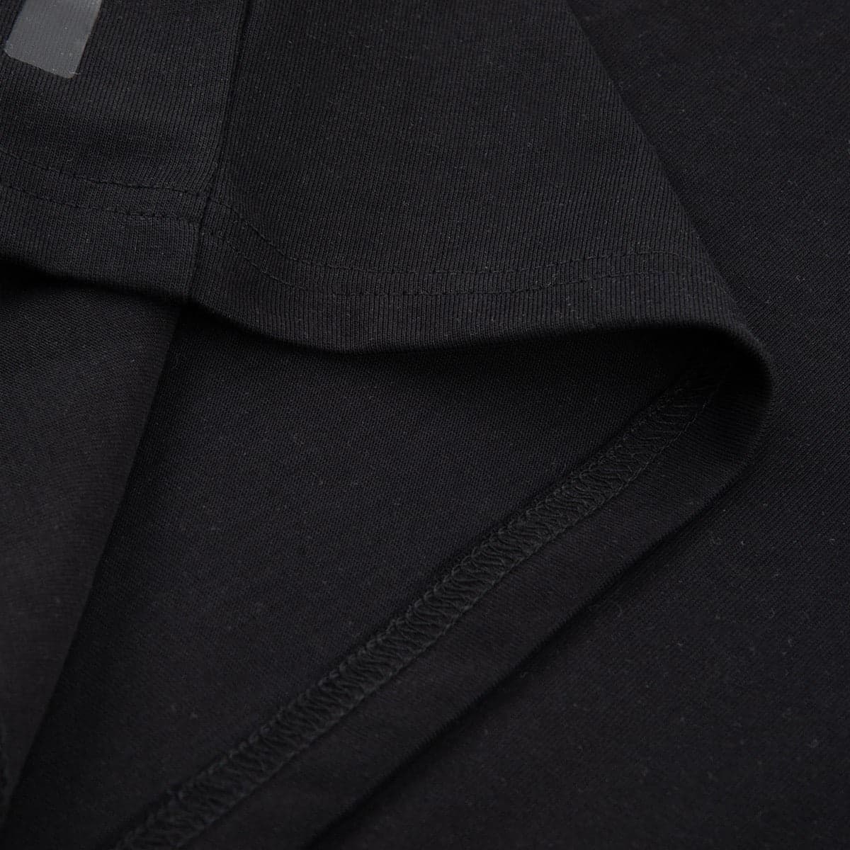 Close-up of the sleeve hem stitching on the heavyweight black cotton