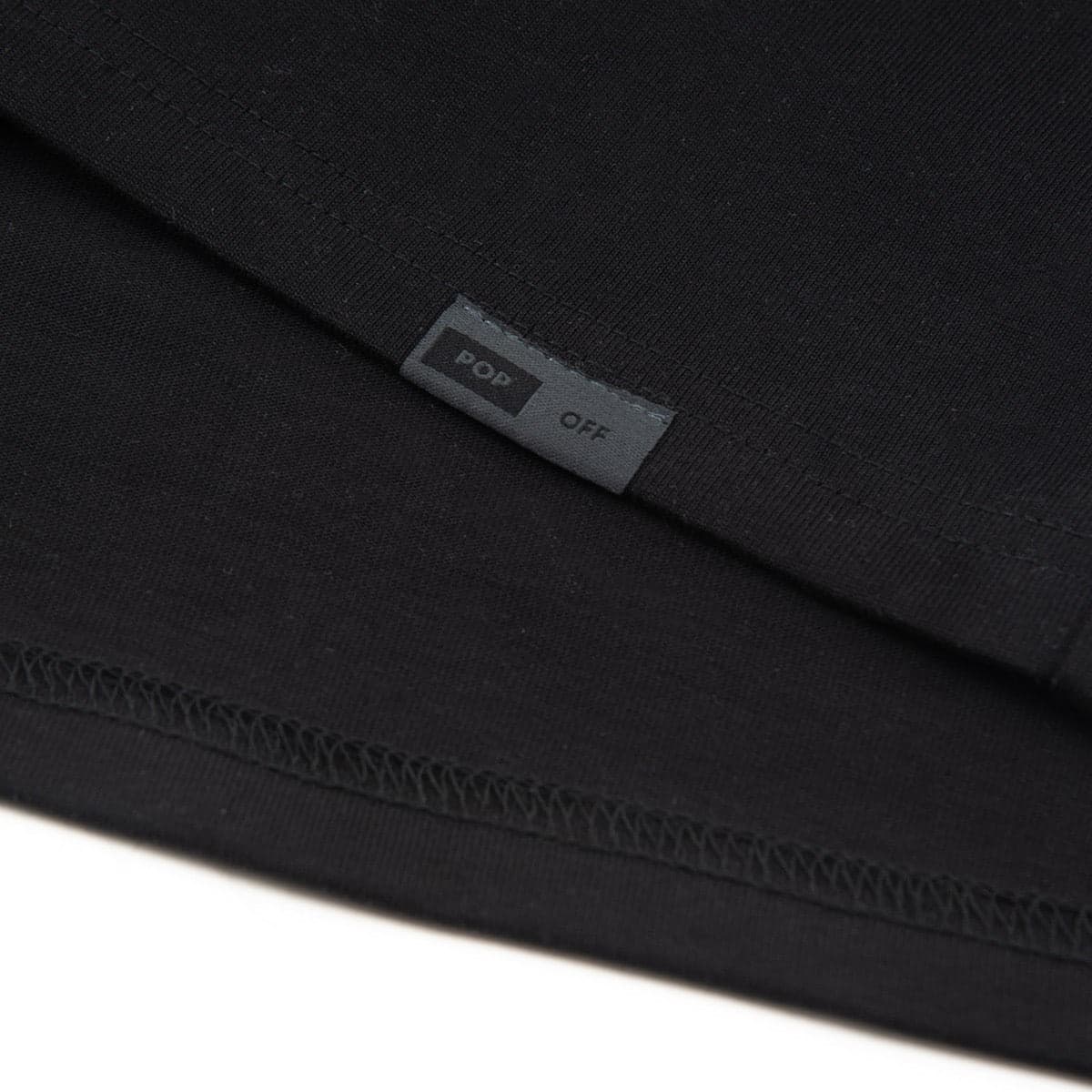 Close-up of the woven Popoff tab stitched at the hem
